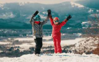 kids on skis on top of a mountain